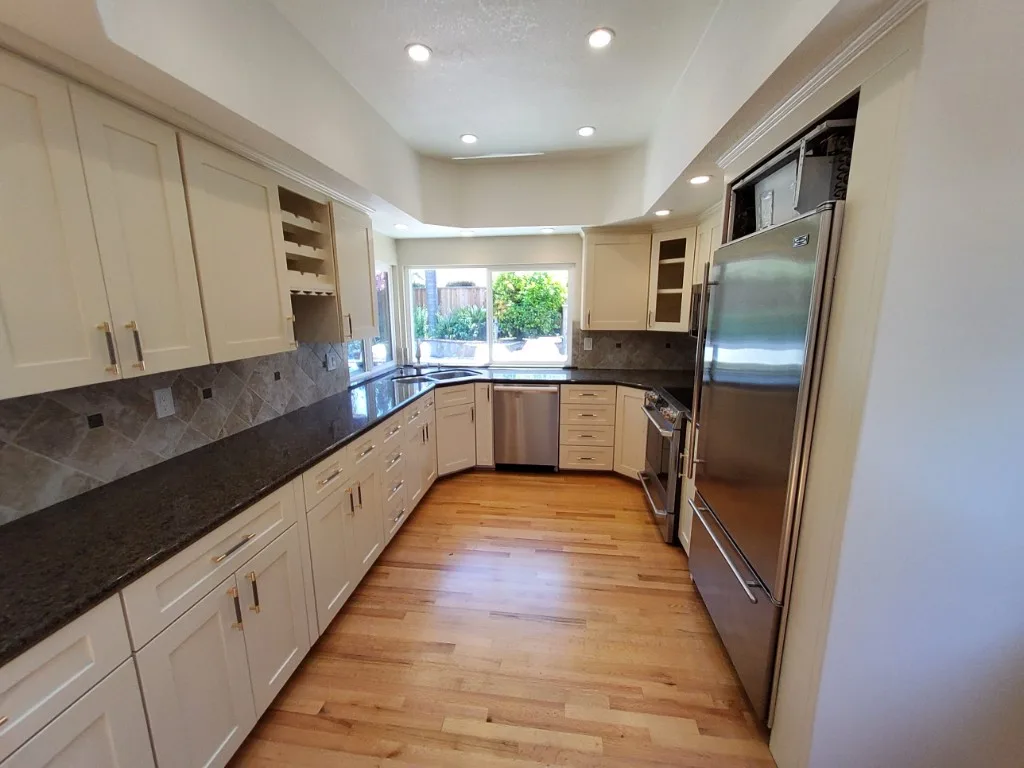 Refinished galley kitchen with cream cabinets